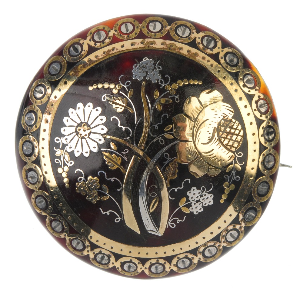 A late 19th century pique tortoiseshell brooch. The foliate motif, within a geometric border.