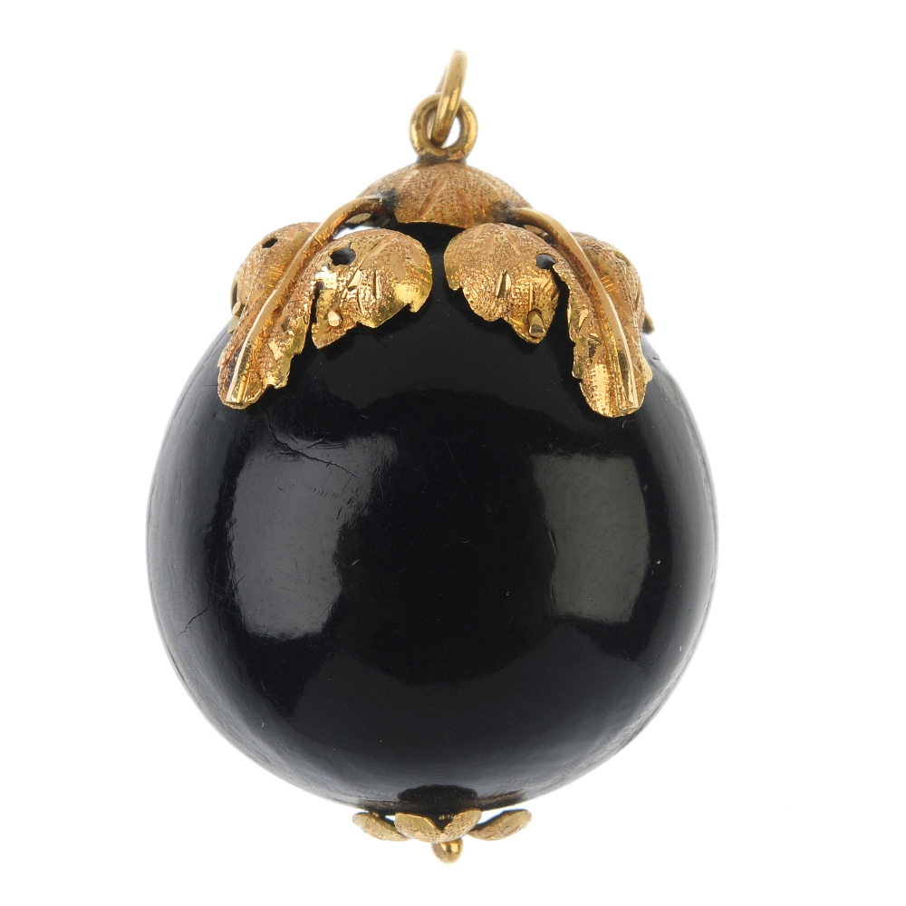 A late 19th century mounted seed pendant. The polished Caribbean drift seed, with foliate cap and