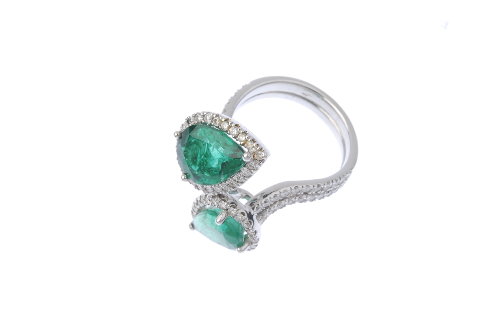 An emerald and diamond crossover ring. Designed as two graduated pear-shape emeralds, each within - Image 2 of 3