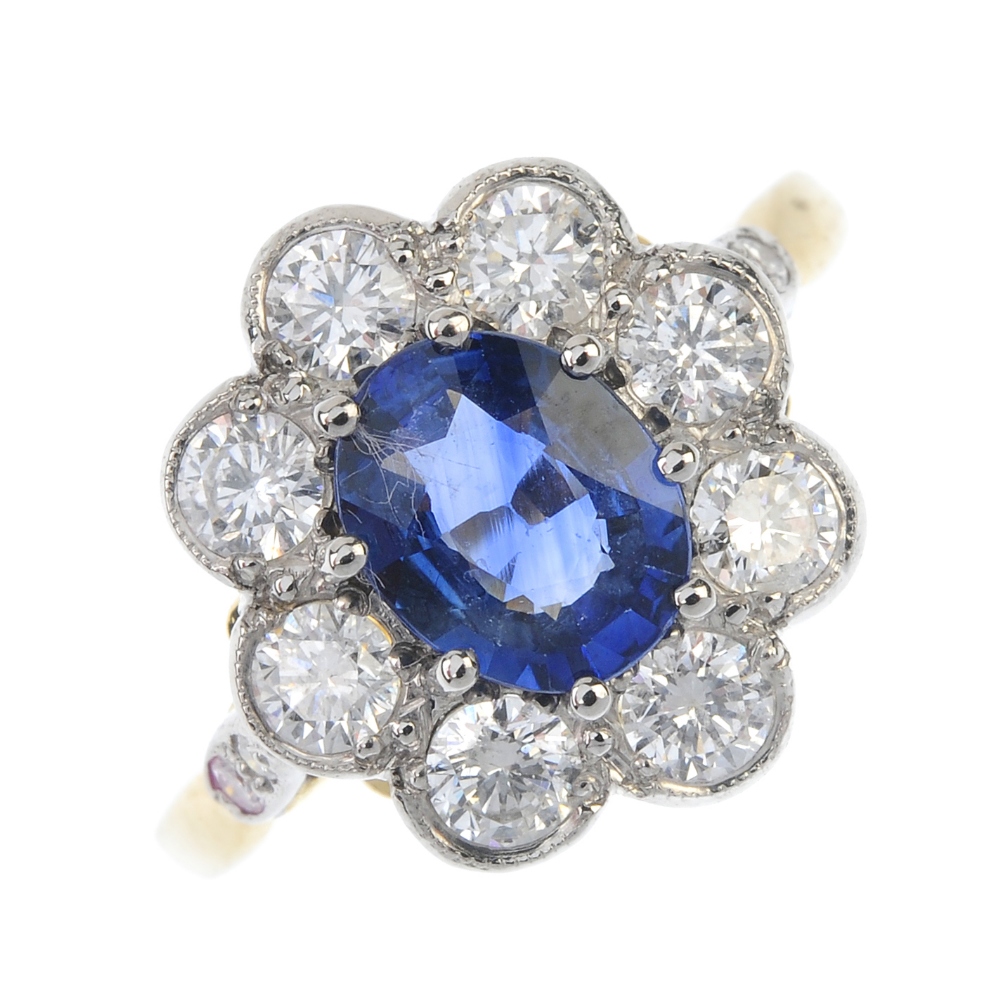 A sapphire and diamond cluster ring. The oval-shape sapphire, within a brilliant-cut diamond