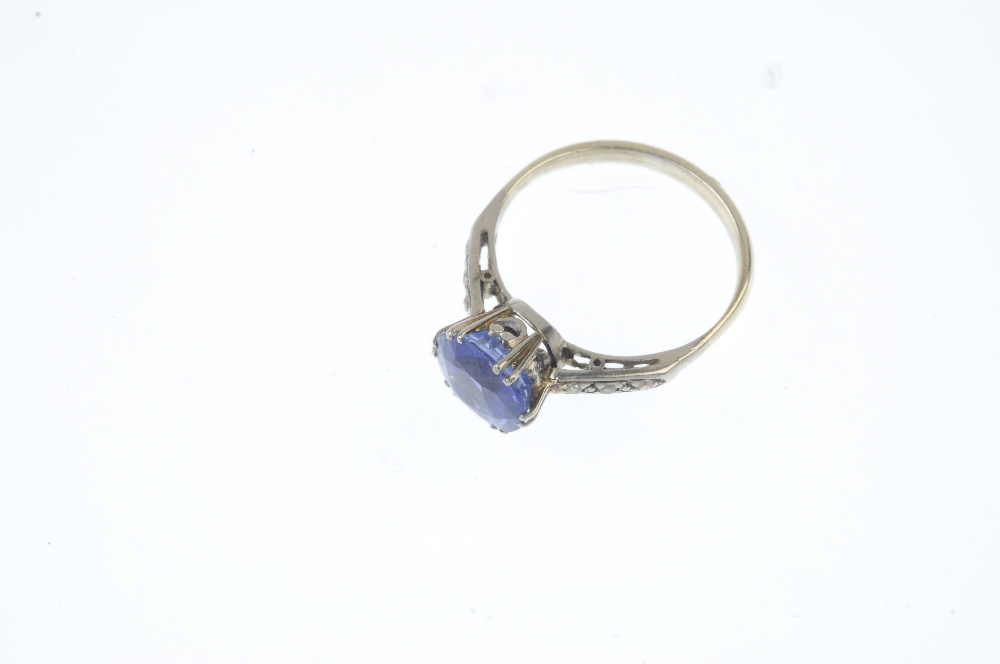 A sapphire and diamond ring. The circular-shape sapphire, with single-cut diamond line shoulders, to - Image 2 of 3