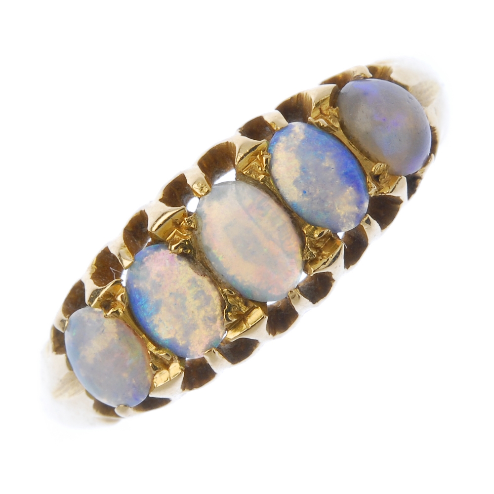 An early 20th century 18ct gold opal ring. The oval opal cabochon graduated line, to the openwork