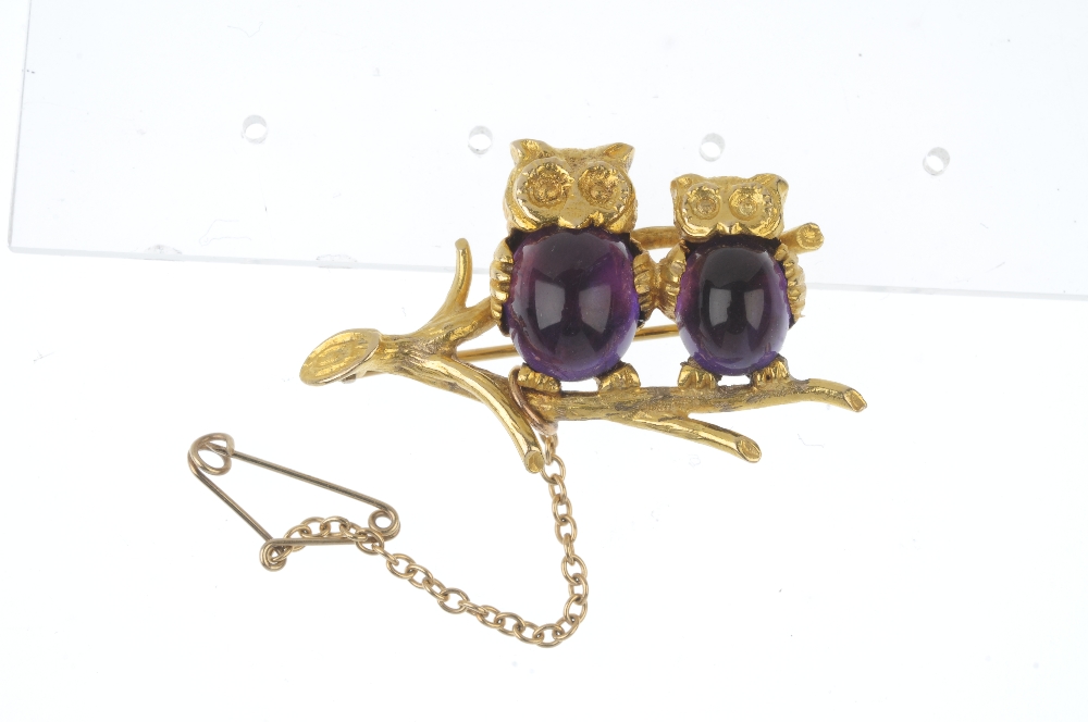 A 9ct gold amethyst owl brooch. Designed as two owls, with oval amethyst cabochon bodies, perched - Image 3 of 3