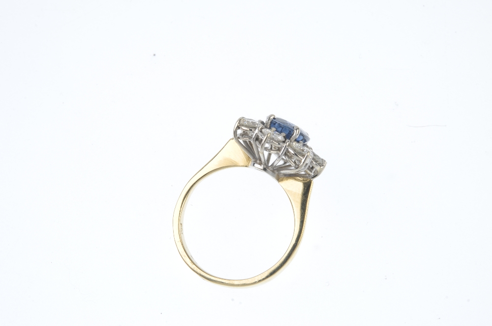 An 18ct gold sapphire and diamond cluster ring. The oval-shape sapphire, within a brilliant-cut - Image 3 of 3