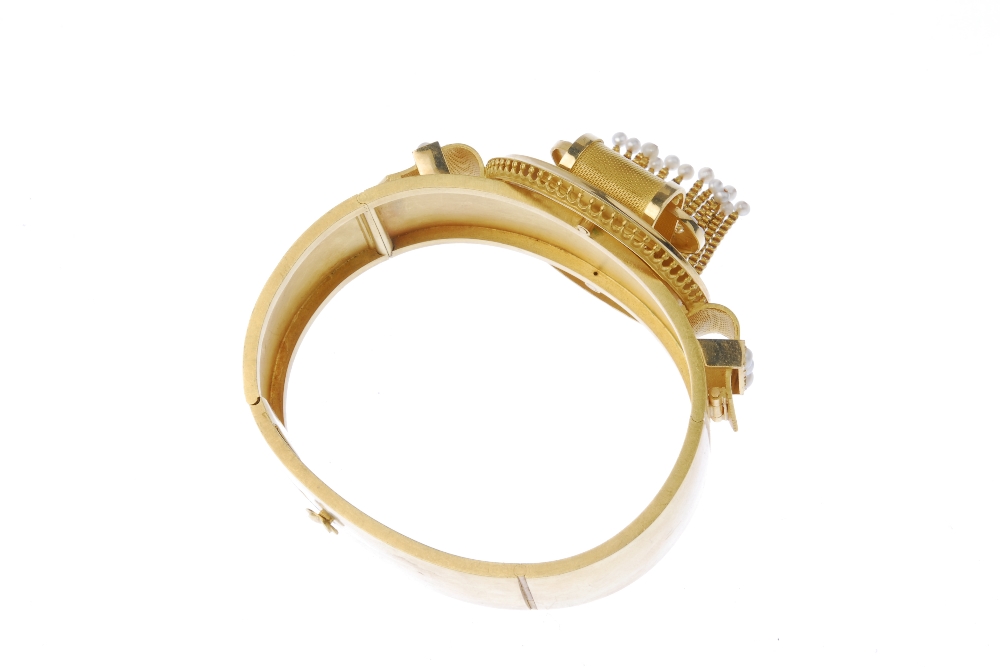 A late 19th century gold seed pearl hinged bangle. Designed as a stylised buckle, with central - Image 2 of 6