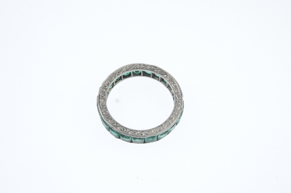 An emerald full-circle eternity ring. The square-shape emerald line, with scrolling engraved - Image 2 of 3