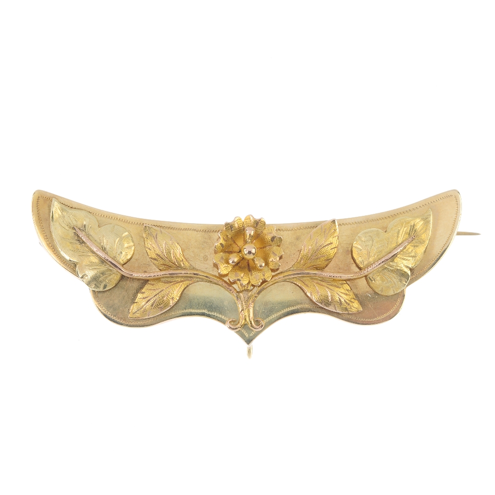 A late 19th century gold brooch. The textured, bi-colour floral motif, raised to the scalloped