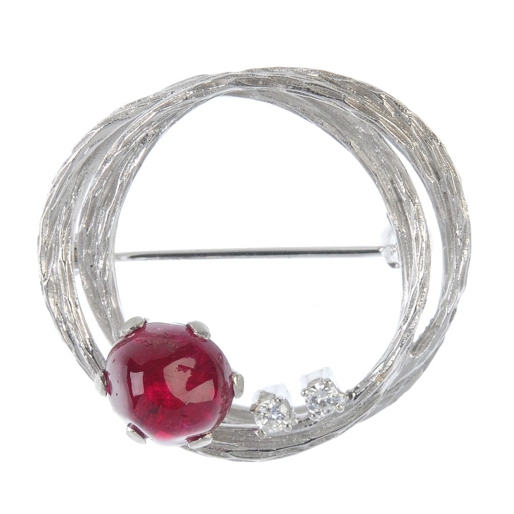 A 1970s ruby and diamond brooch. The textured wreath, with ruby cabochon and twin brilliant-cut