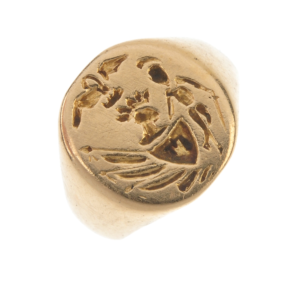 A signet ring. The circular-shape panel, with  engraved crest, to the tapered shoulders. Ring size