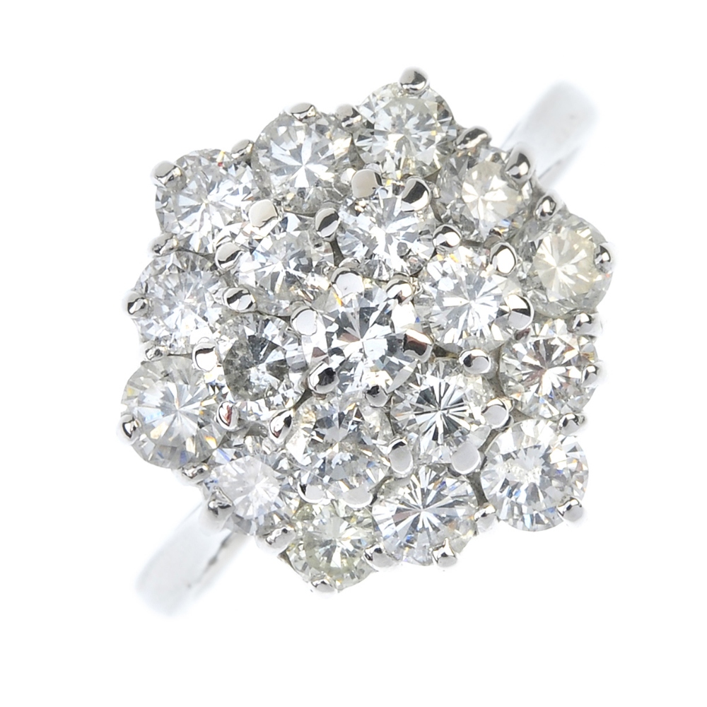 A diamond cluster ring. Designed as a brilliant-cut diamond stepped cluster, to the tapered band.