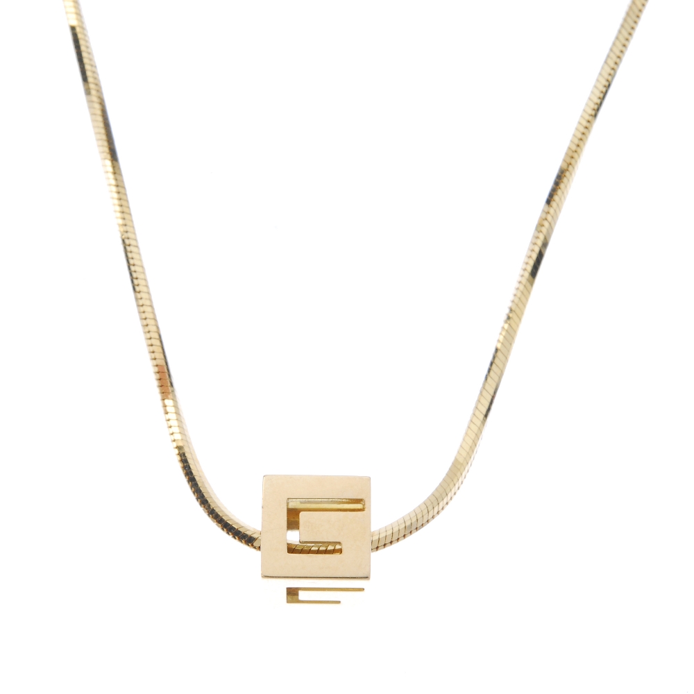 GUCCI - a set of jewellery. The pendant designed as a cube, with pierced G detail, suspended from