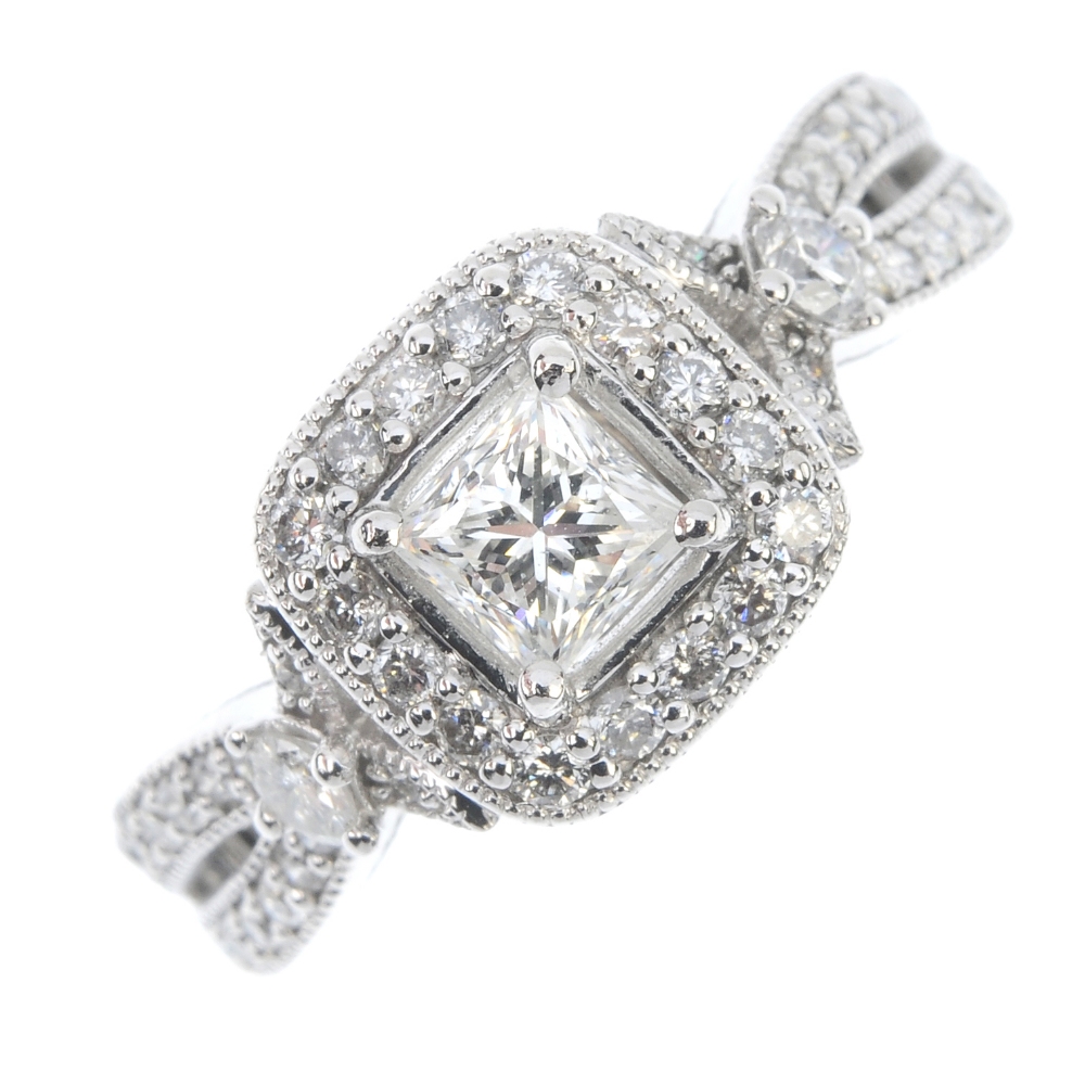 A diamond cluster ring. The square-shape diamond, within a pave-set diamond border to the pave-set