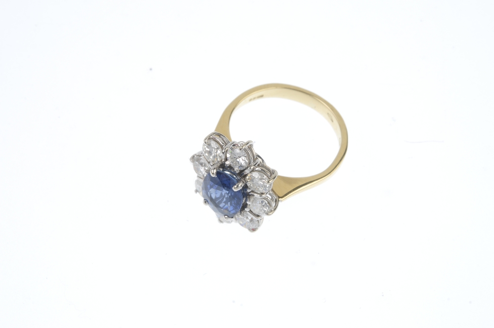 An 18ct gold sapphire and diamond cluster ring. The oval-shape sapphire, within a brilliant-cut - Image 2 of 3