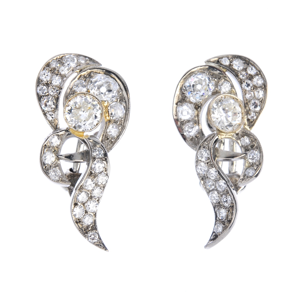 A pair of diamond earrings. Each designed as a circular-cut diamond collet, within an old and