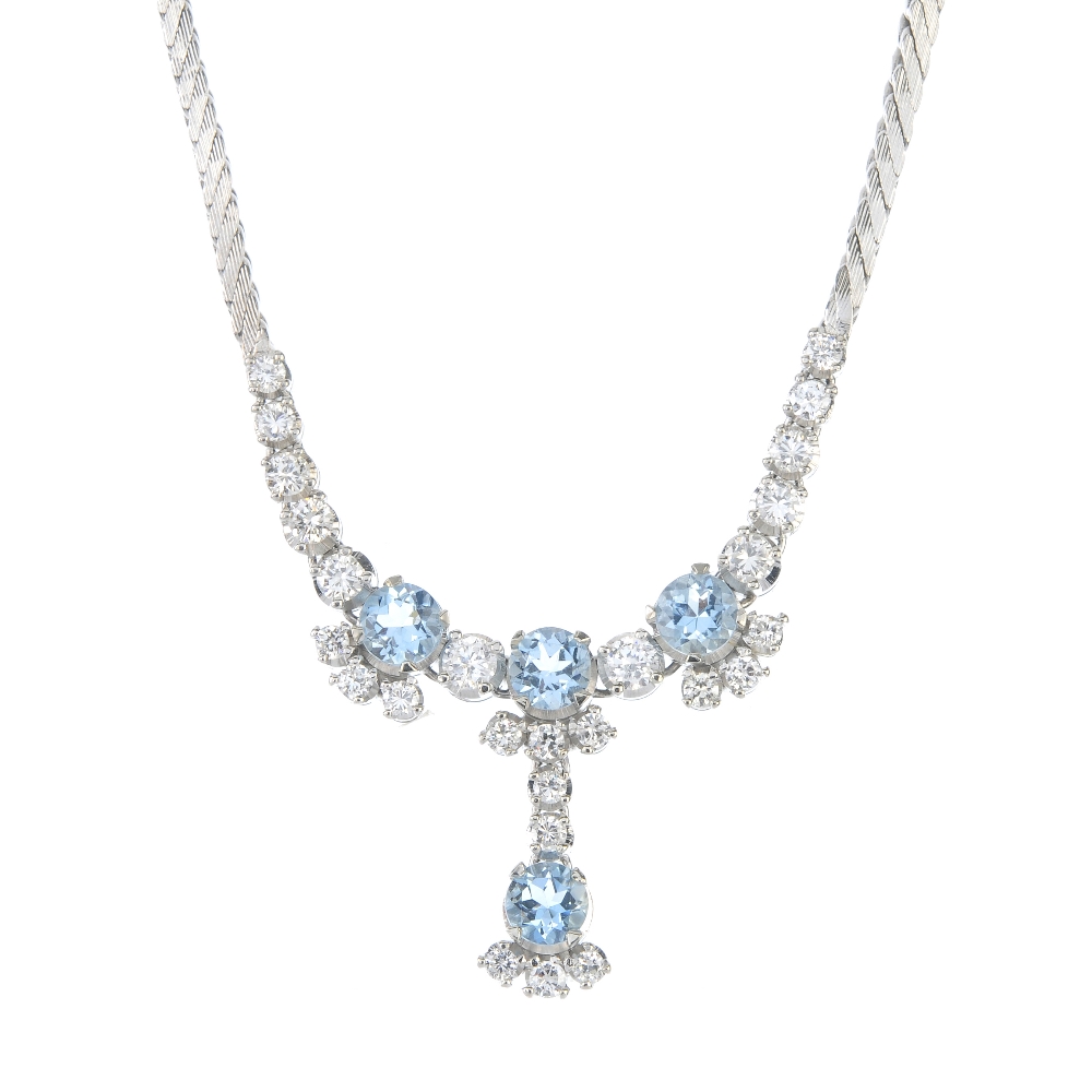 An aquamarine and diamond necklace. The front designed as a series of circular-shape aquamarines,