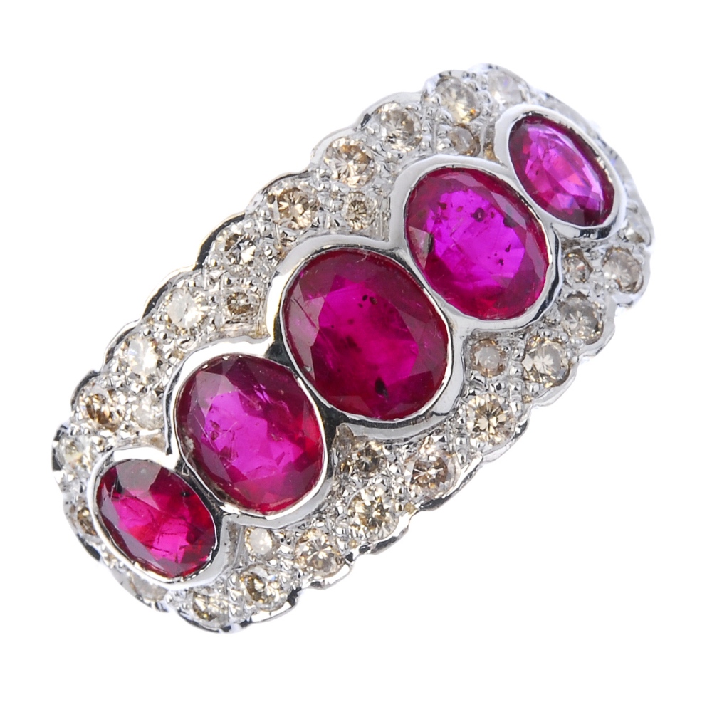 A ruby and diamond dress ring. The oval-shape ruby collet graduated line, within a brilliant-cut