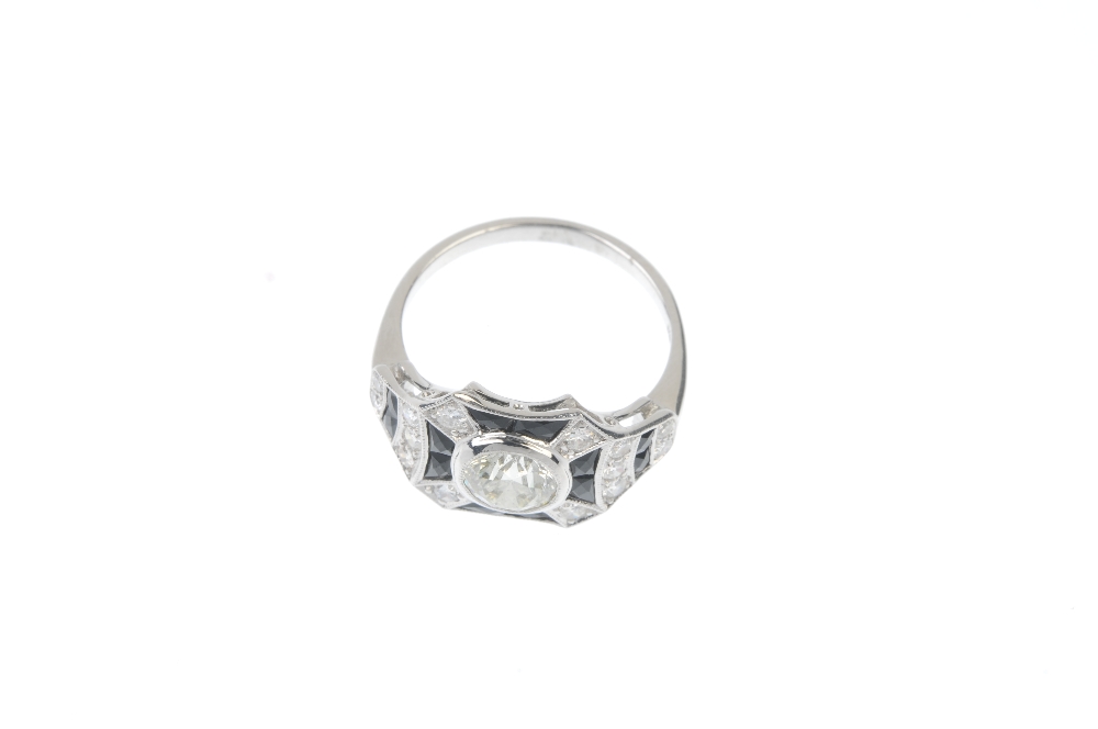 A diamond and onyx dress ring. The brilliant-cut diamond collet, within a calibre-cut black onyx and - Image 2 of 3
