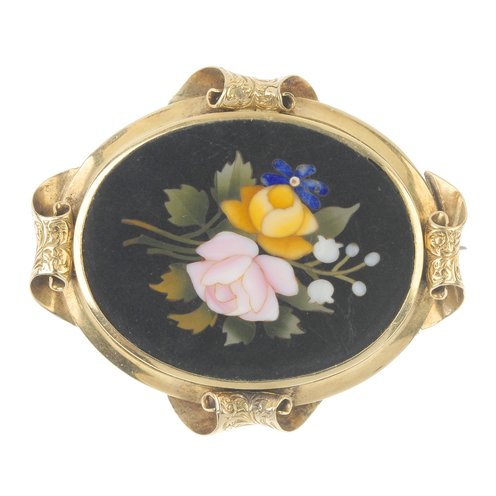A gold pietra dura brooch. Of oval outline, the floral hardstone panel, within a scrolling foliate