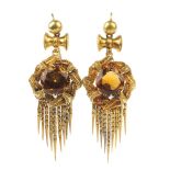 A pair of citrine ear pendants. Each designed as a circular-shape citrine, with entwined foliate