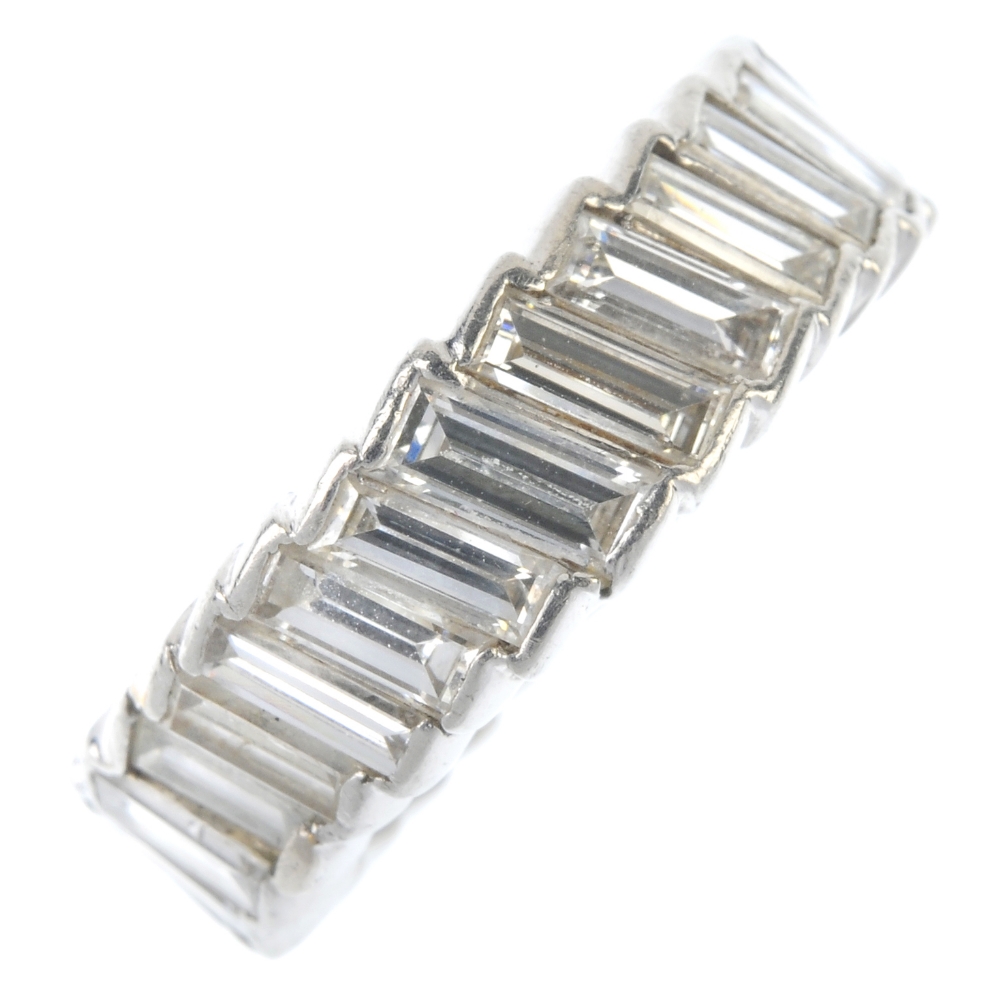 A diamond full-circle eternity ring. Designed as a baguette-cut diamond line, set at an angle.