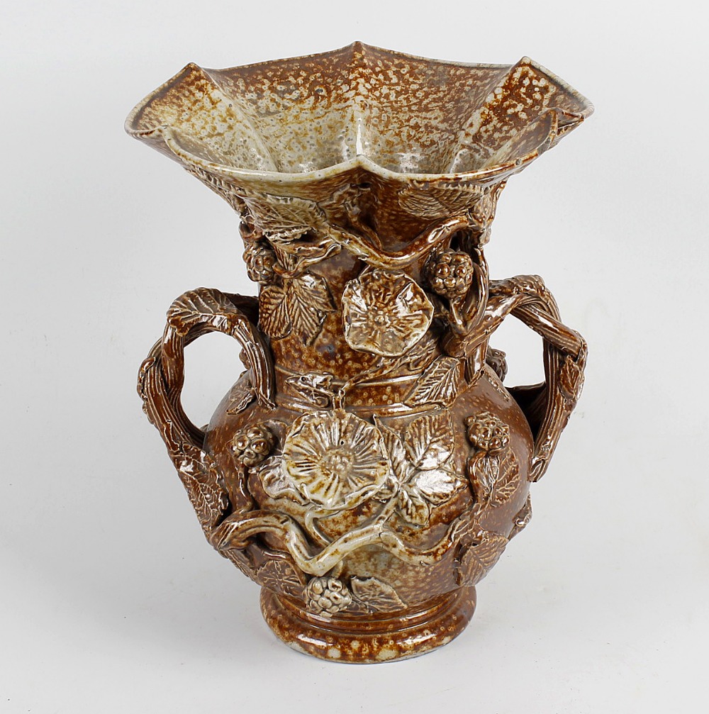 A saltglazed stoneware twin handled vase, of bulbous form below a tall flared and lobed neck, the