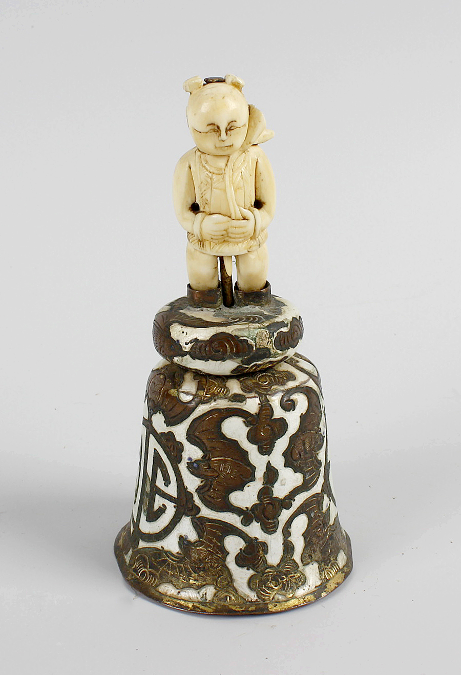 A late 19th century Chinese table bell, the enameled shaped bell engraved with a band of bats, and