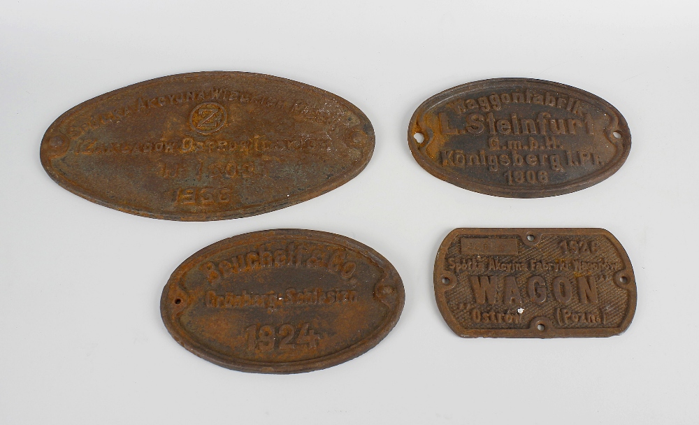 A box containing seven vintage railway wagon cast iron plates, to include an America and German