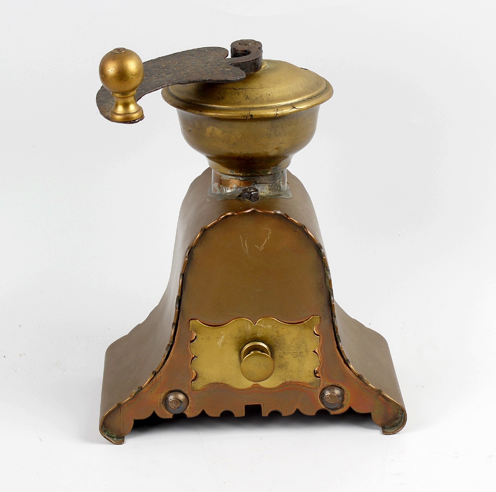 A copper and brass coffee mill, of arched form having scalloped edges and single brass drawer
