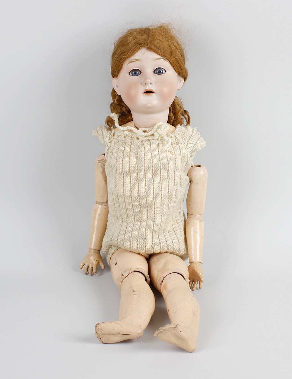 An A W German bisque headed doll, modelled as a young girl with opening blue glass eyes and partly
