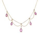 An Edwardian 9ct gold tourmaline and seed pearl necklace. The graduated pear-shape pink tourmaline