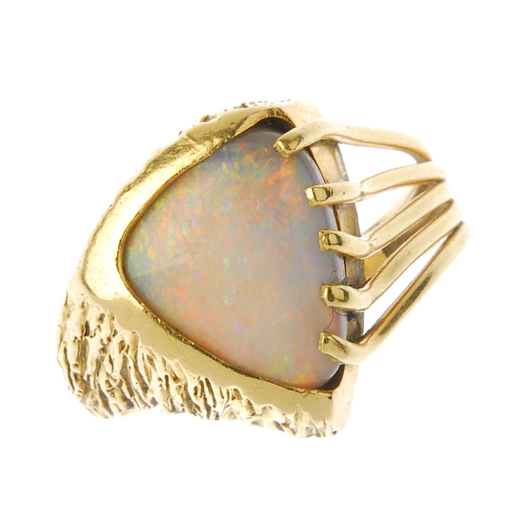 (87812) An opal dress ring. The triangular opal cabochon, with openwork and textured sides. Ring