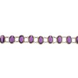 A mid 20th century paste bracelet. Designed as a series of oval-shape purple paste, to the belcher-