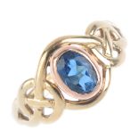 CLOGAU - a 9ct gold topaz ring and key charm. The bi-colour ring set with an oval blue topaz with