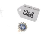 (PWN708) An 18ct gold sapphire and diamond cluster ring. The oval-shape sapphire within a