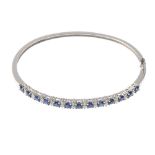 (112531) A sapphire and diamond hinged bangle. The circular-shape sapphire line, with brilliant-