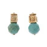 A pair of turquoise earrings. Each designed as a faceted turquoise bead, to the floral motif