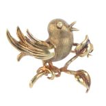 A bird brooch. Designed as a singing bird, perched on a branch. Length 2.7cms. Weight 3.9gms.