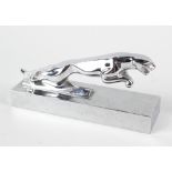 A chrome Jaguar Automobile hood ornament desktop weight, modelled mid leap, on rectangular plinth,