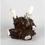 A Japanese Meiji period ivory and lacquer figure of a sage, modelled in seated pose with