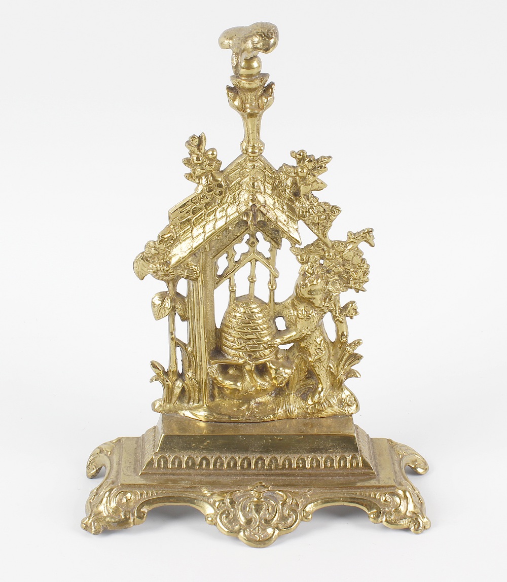 A Victorian brass pocket watch stand, modelled as two bears holding a honey pot beside sunflowers