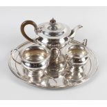 A box of silver plated items, to include a silver plated tea pot, sugar bowl and milk jug on a round