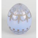 A light blue glass egg, in the manner of Faberge, having incised foliate and swag decoration, 3.5 (