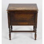 A 1930s oak sewing table, the hinged rectangular top with moulded edge lifting to reveal a plain