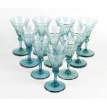 A matching set of twelve Victorian green drinking glasses, the funnel shaped bowl having etched