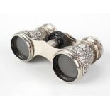 A pair of late Victorian silver mounted opera glasses, having foliate scrollwork embossing to the