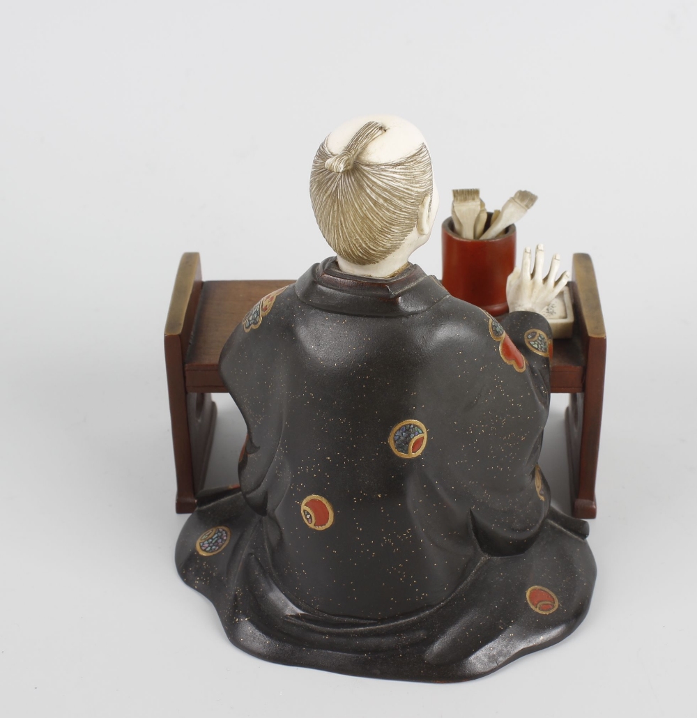 A Japanese Meiji period ivory and lacquer figure of a scholar knelt at a table, with right arm - Image 2 of 3