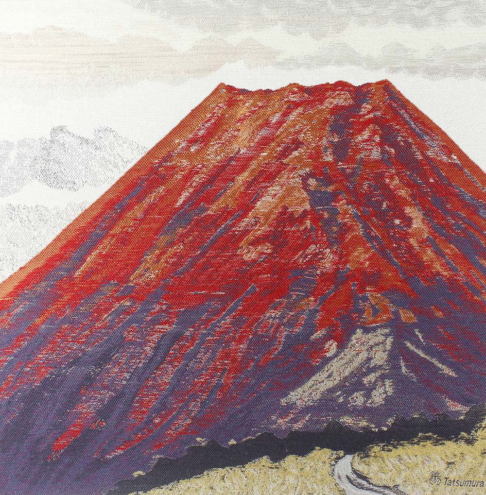 A framed textile work depicting Mount Fiji, 19.5” x 19.25” (49.5cm x 49cm). Fair condition. Frame