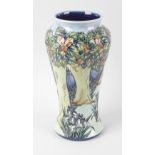 A large modern Moorcroft pottery vase, of baluster form with woodland trees and flowers on a split