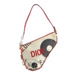 CHRISTIAN DIOR - a hardcore canvas saddle bag and lipstick case. Designed with a bold red and