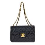 CHANEL - a Maxi Classic Flap handbag. Featuring maker's signature black quilted lambskin leather